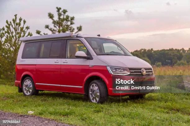 Красный И Белый Цвета Современного Volkswagen Multivan California Ocean Припаркован В Лесу На Рассвете Вид Спереди — стоковые фотографии и другие картинки фольксваген фургон-0